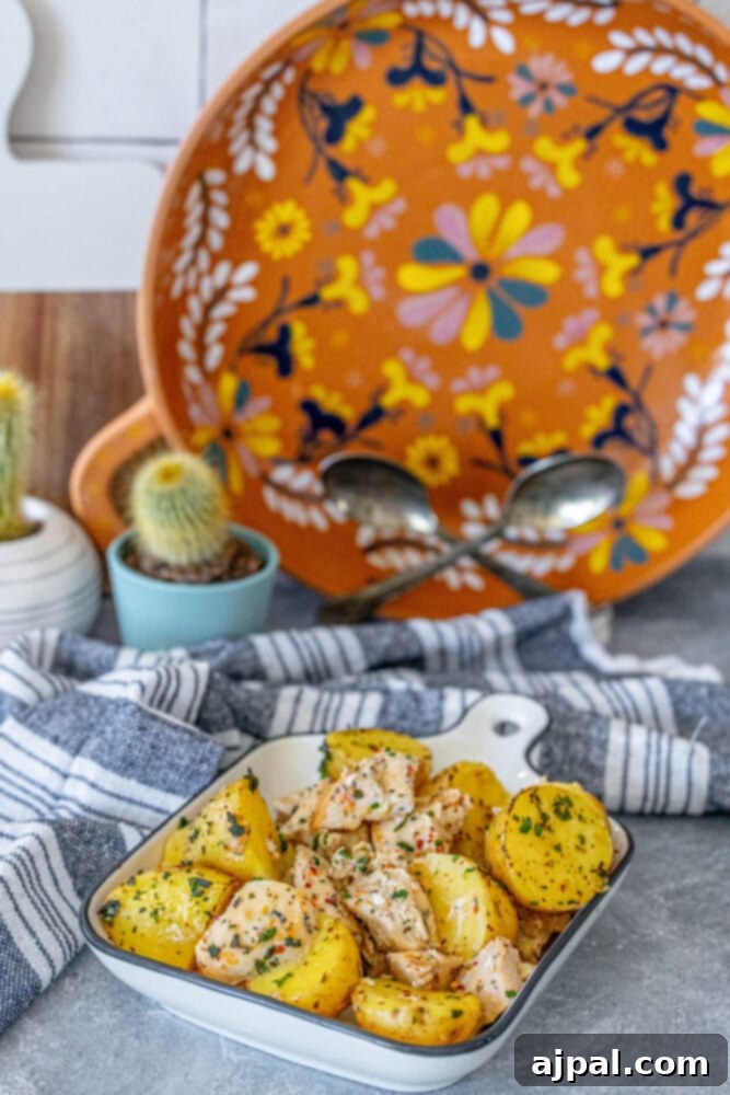 Zesty Lemon Garlic Chicken with Roasted Potatoes 7 A white dish filled with golden-brown lemon garlic chicken and potatoes, ready for serving.