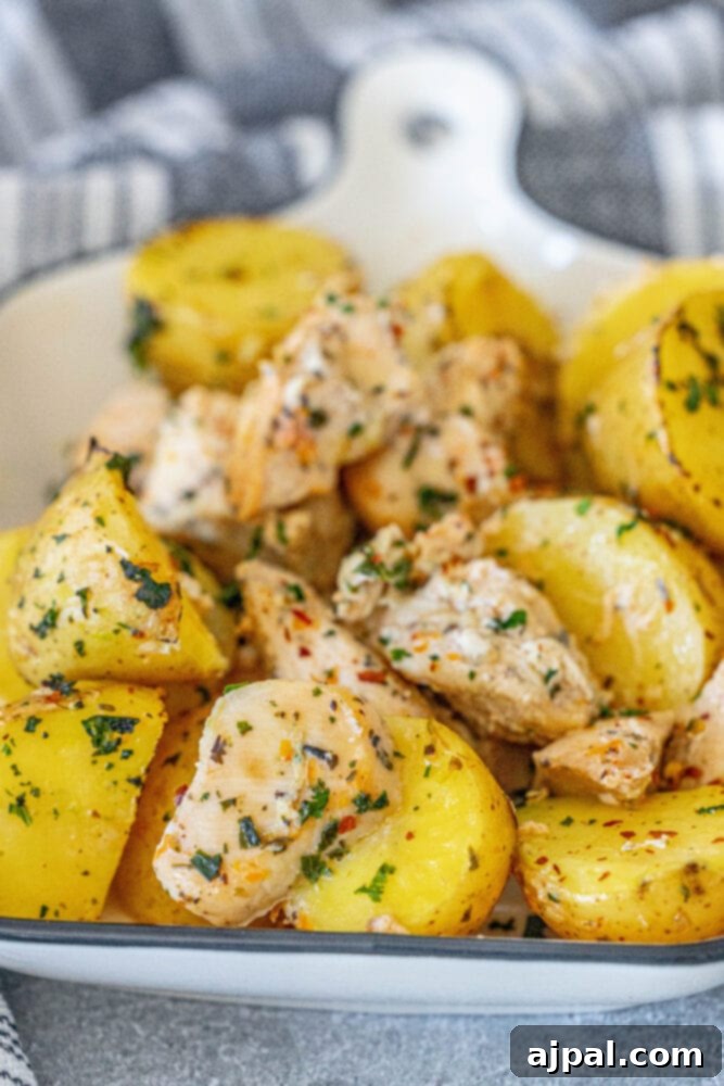Zesty Lemon Garlic Chicken with Roasted Potatoes 4 A close-up view of baked chicken and potatoes with fresh herbs, showcasing the golden-brown crispness.
