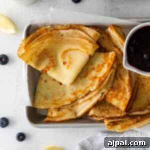 picture of lemon blueberry crepes on a dish with blueberry sauce