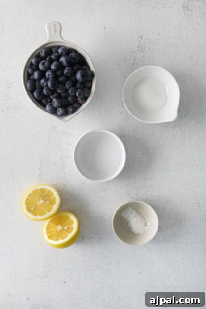 Fresh blueberries and vibrant lemons on a pristine white surface, highlighting key ingredients for the recipe.