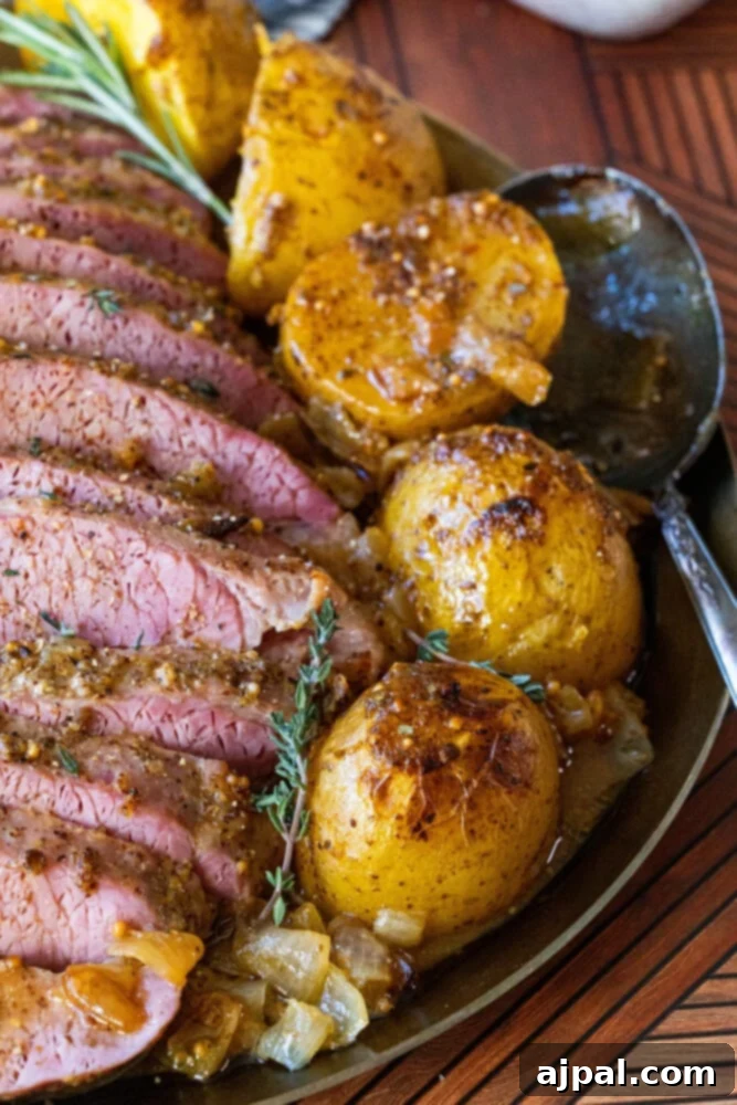 Another view of the delicious baked honey mustard corned beef and potatoes on a platter, showcasing the tenderness of the meat.