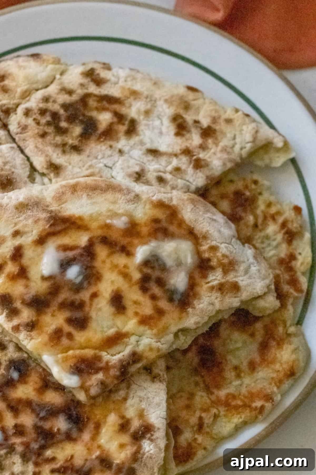 Close-up of several pieces of Irish potato bread, with browned, flaky surfaces on a white plate.