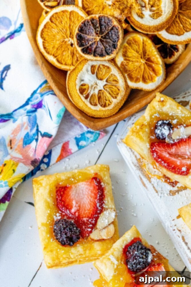 Bright Lemon Berry Tarts 13 Artfully arranged lemon berry baked tarts on a white cutting board, showcasing their vibrant colors and flaky crusts, garnished with fresh berries and almonds.