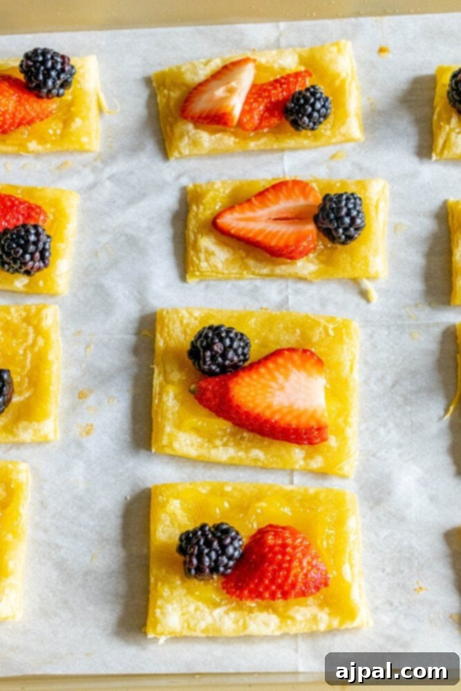 Bright Lemon Berry Tarts 8 An unbaked lemon curd tart, topped with vibrant berries, artfully arranged on a baking sheet, ready for the oven.