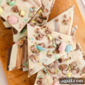 picture of white chocolate and chocolate layered easter bark with cadbury mini eggs on a wood cutting board