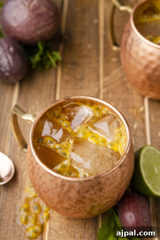 Passion Tempest 11 Passion Fruit Dark and Stormy cocktail in a copper mug with a lime garnish.