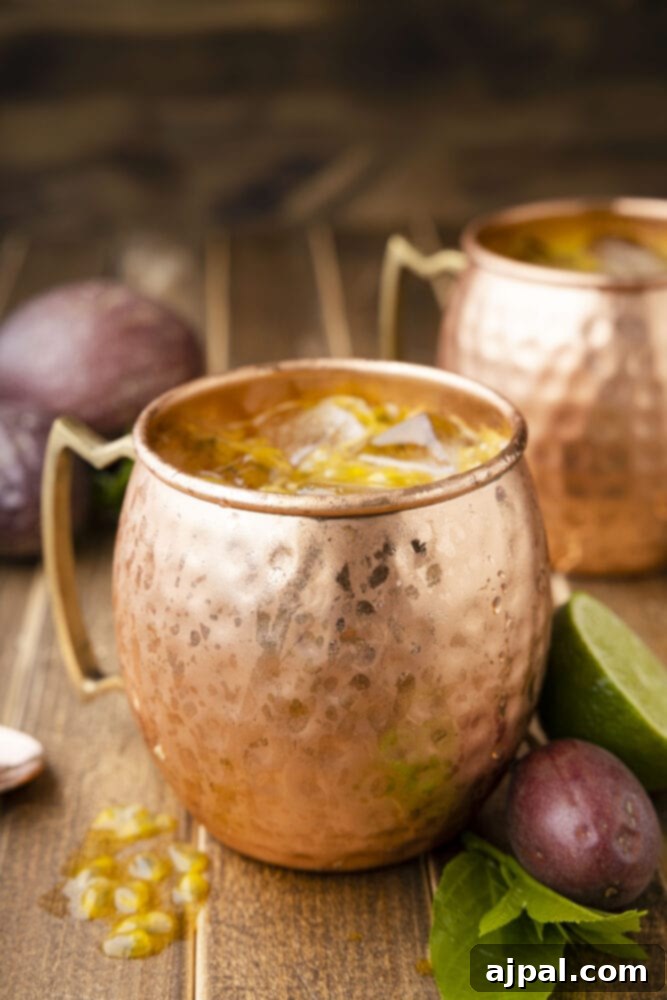 Passion Tempest 14 Passion Fruit Dark and Stormy cocktail in a copper mug, garnished with a lime wheel.