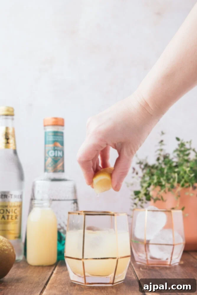 Golden Pear Fizz 8 picture of a hand squeezing lemon juice into a glass