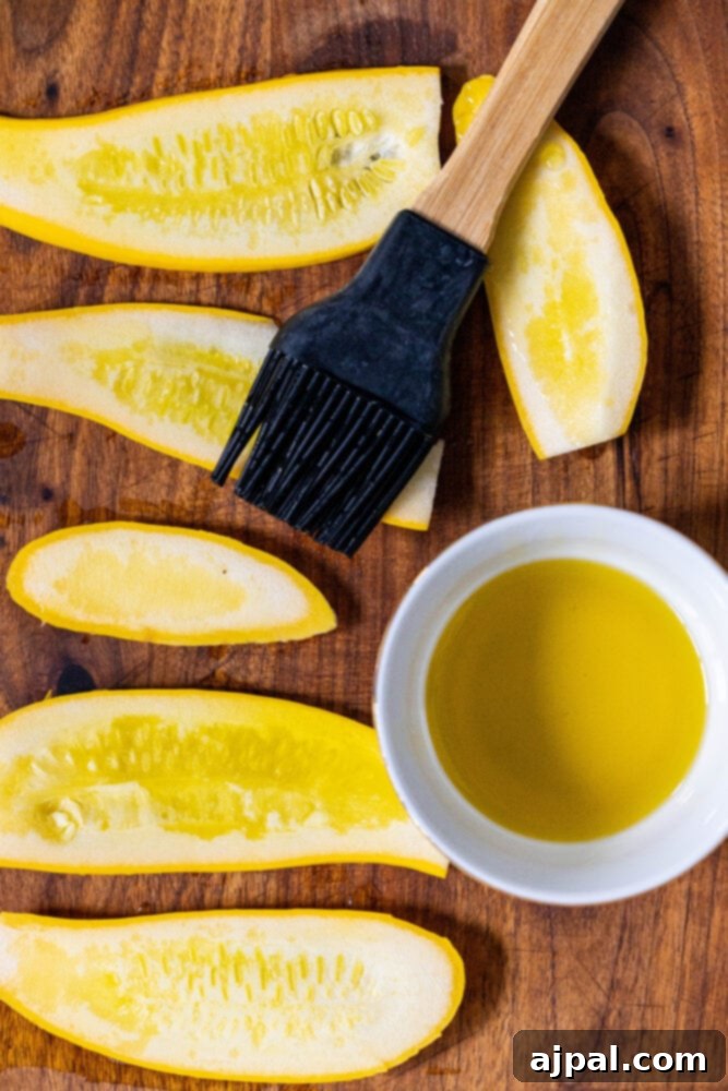 Grilled Summer Squash Medley 6 picture of sliced yellow squash and a silicone brush with avocado oil on a cutting board