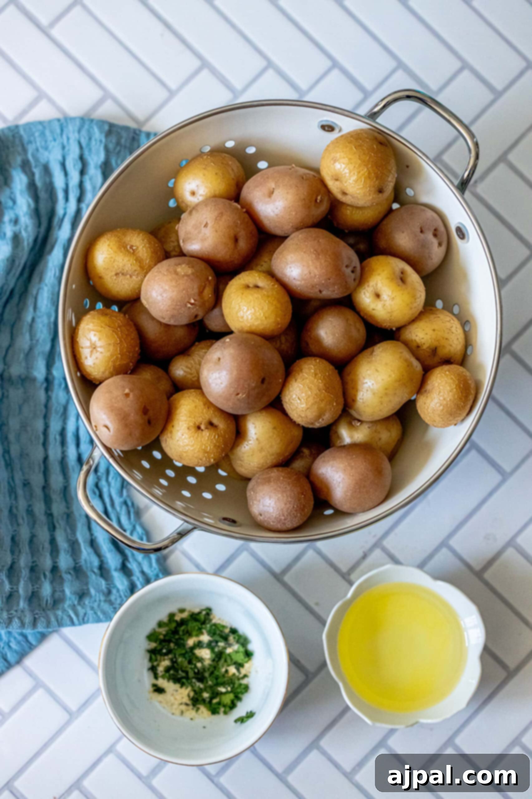 Chopped potatoes in a colander, glistening with oil and seasonings, ready for grilling.
