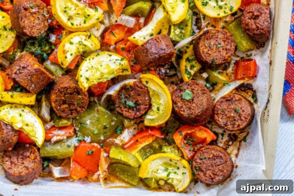 One-Pan Vegan Chorizo Veggie Bake 3 picture of baked vegan chorizo sausage, squash, peppers, onions, and mushrooms on a baking sheet