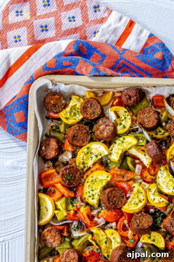 One-Pan Vegan Chorizo Veggie Bake 8 picture of baked vegan chorizo sausage, squash, peppers, onions, and mushrooms on a baking sheet