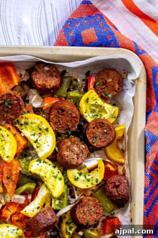 One-Pan Vegan Chorizo Veggie Bake 10 picture of baked vegan chorizo sausage, squash, peppers, onions, and mushrooms on a baking sheet