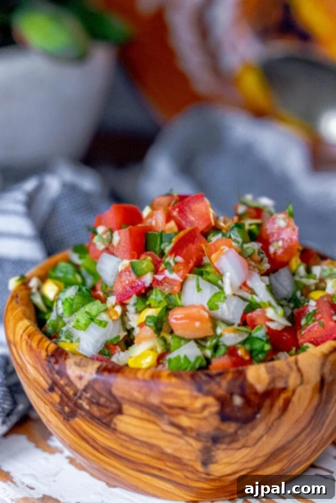 Whip Up Corn Pico De Gallo 2 Picture of corn pico de gallo in a wooden bowl, showcasing its fresh ingredients and vibrant colors.