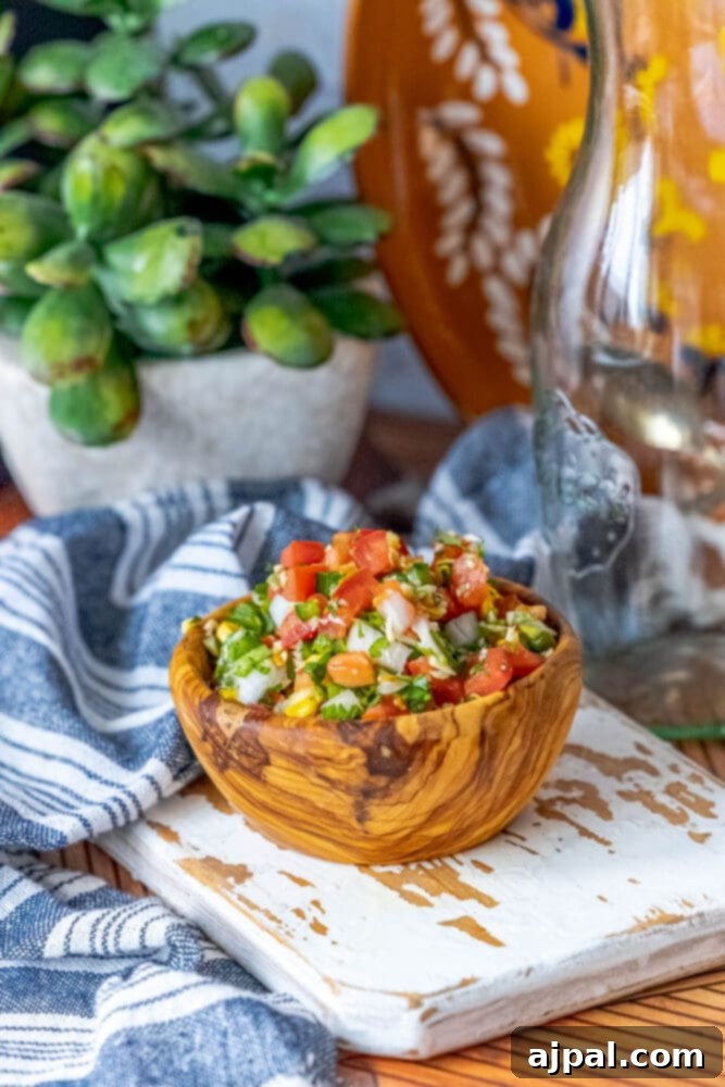 Whip Up Corn Pico De Gallo 4 A bowl of Easy Corn Pico De Gallo on a wooden cutting board, ready to be served.