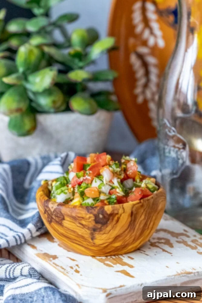 Whip Up Corn Pico De Gallo 6 A bowl of Easy Corn Pico De Gallo on a wooden cutting board, brightly colored.