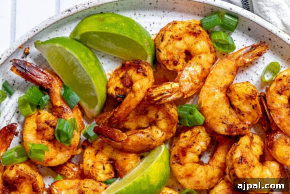 picture of jerk shrimp on a white plate with sliced green onions and limes