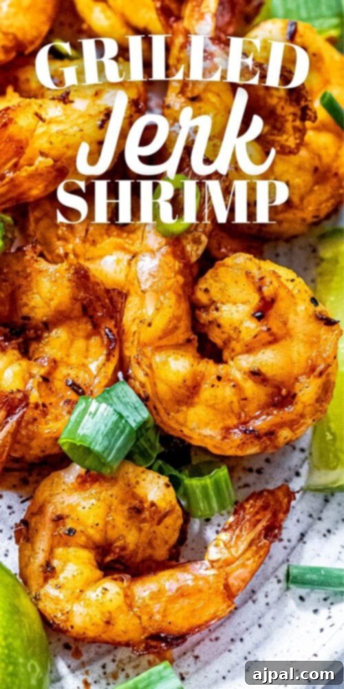 picture of jerk shrimp on a white plate with sliced green onions and limes