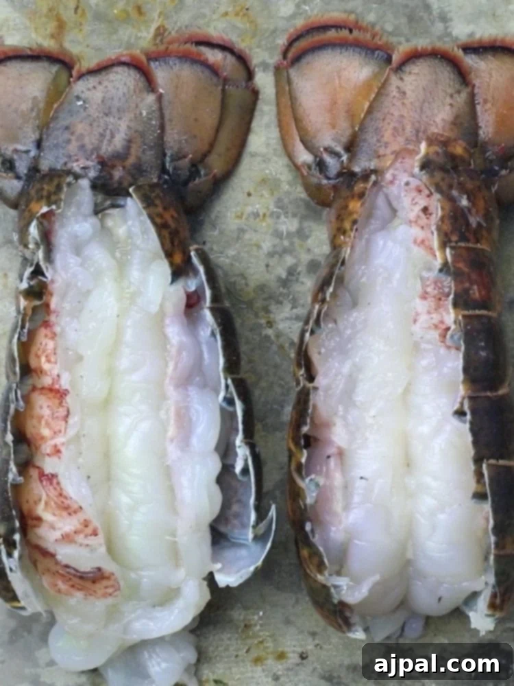 Perfect Grilled Lobster Tails 6 Butterflied lobster tail on a baking sheet, showing the exposed meat.