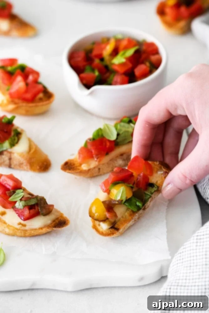 Vibrant Caprese Toasts 2 Delicious Caprese Bruschetta appetizers arranged on a rustic wooden table, garnished with fresh basil leaves.