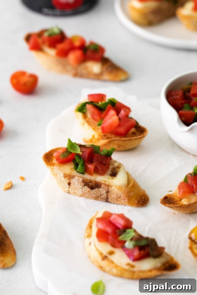 Fresh Caprese Bruschetta 10 An appetizing spread of Caprese Bruschetta pieces, each a delightful bite of fresh Italian flavor, presented on a white dish.