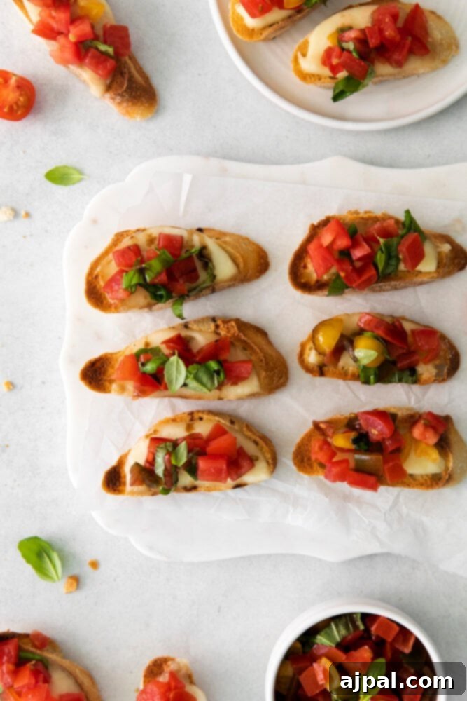 Fresh Caprese Bruschetta 7 A close-up view of perfectly assembled Caprese Bruschetta, garnished with flaky sea salt, on a elegant white serving plate.