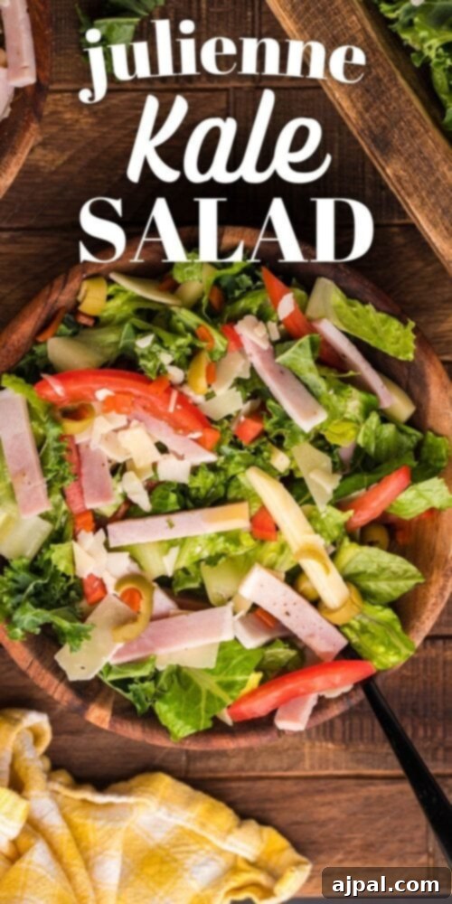 Crisp Julienne Kale Salad 7 picture of julienne kale salad with meat cheese and vegetables with a Mediterranean dressing in a wood bowl on a table