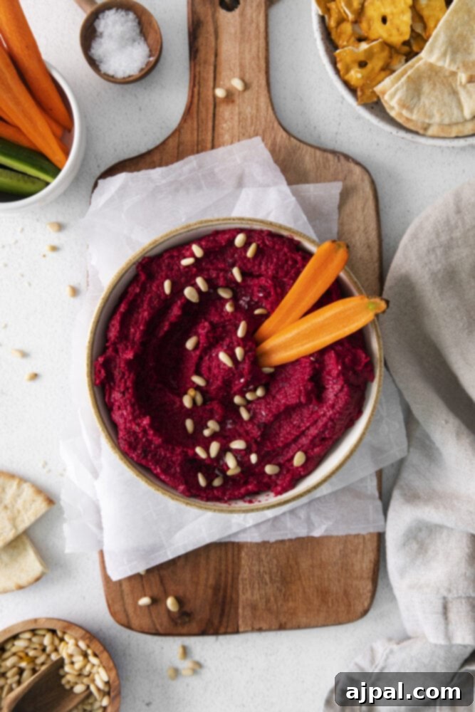 Vibrant Roasted Beet Hummus 3 A flavorful bowl of roasted beet hummus served with carrots and crackers.