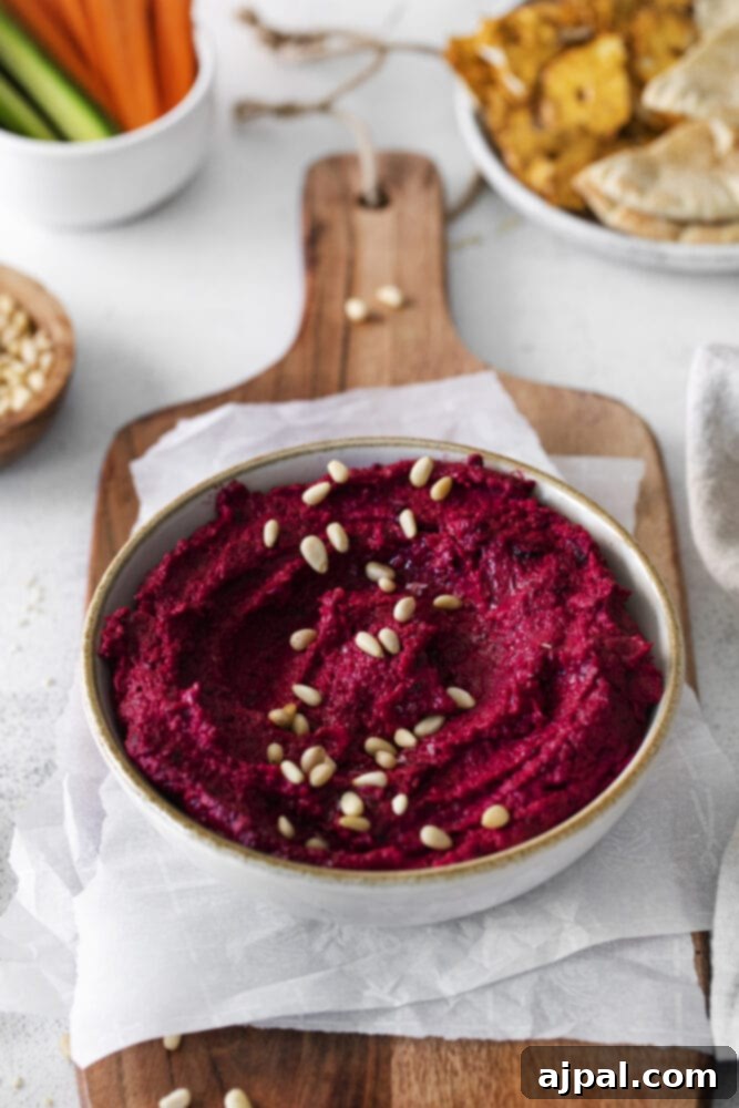 Vibrant Roasted Beet Hummus 9 Roasted Beet Hummus on a wooden cutting board.