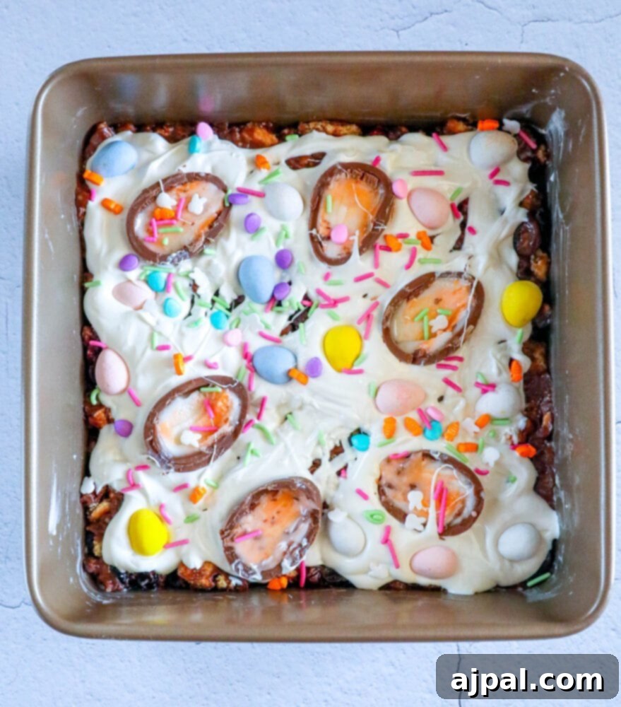 Rocky Road Bars: Cadbury Creme Egg Edition 12 An Easter cake, richly frosted and decorated with Cadbury Creme Eggs and colorful sprinkles.