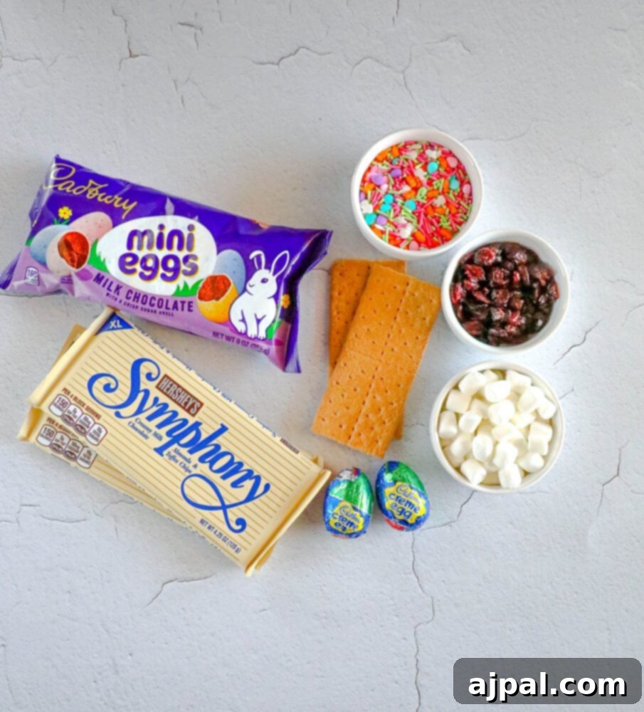 Rocky Road Bars: Cadbury Creme Egg Edition 5 A vibrant collection of Easter basket ingredients: Cadbury Creme Egg Rocky Road Bars and chocolate bark spread on a table, ready for creation.