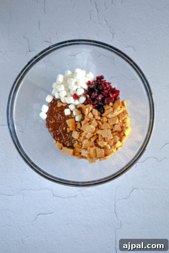 Rocky Road Bars: Cadbury Creme Egg Edition 7 A bowl overflowing with dried cranberries, mini marshmallows, and crushed Graham crackers, key ingredients for rocky road.