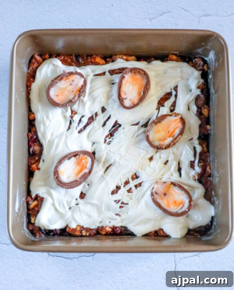 Rocky Road Bars: Cadbury Creme Egg Edition 10 A baking dish showcasing the Cadbury Creme Egg dessert, beautifully adorned with whole and halved Cadbury Mini Eggs and colorful sprinkles.