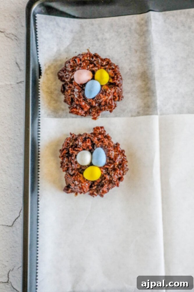 Easter Egg Nest Delights 11 Two freshly shaped Easter Nest Cookies are cooling on wax paper, waiting for their candy egg toppings.