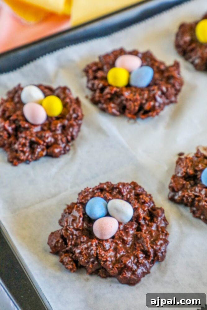 Easter Egg Nest Delights 13 Close-up of chocolate Easter nest cookies arranged on a baking sheet, topped with colorful mini eggs.
