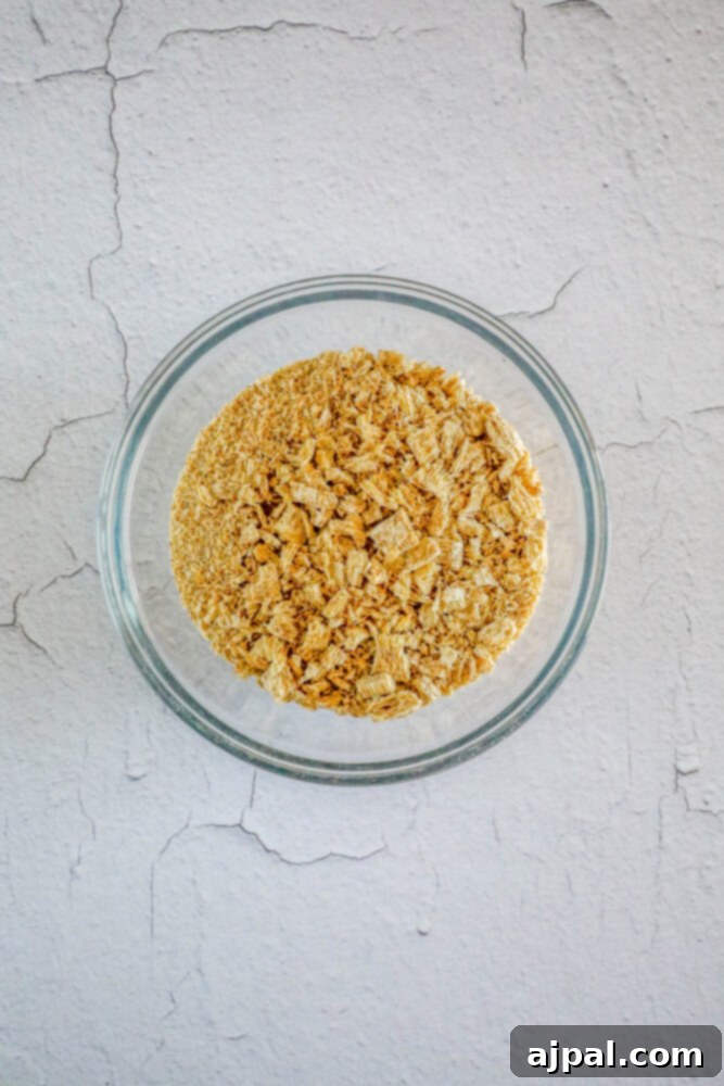 Easter Egg Nest Delights 9 Crushed shredded wheat in a glass bowl, prepared to be mixed with the chocolate coating.