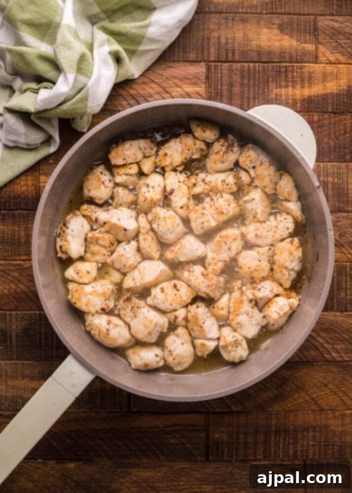 Velvet Chicken Bacon Pasta Salad 6 Chicken pieces browning in a hot frying pan, sizzling in bacon grease.