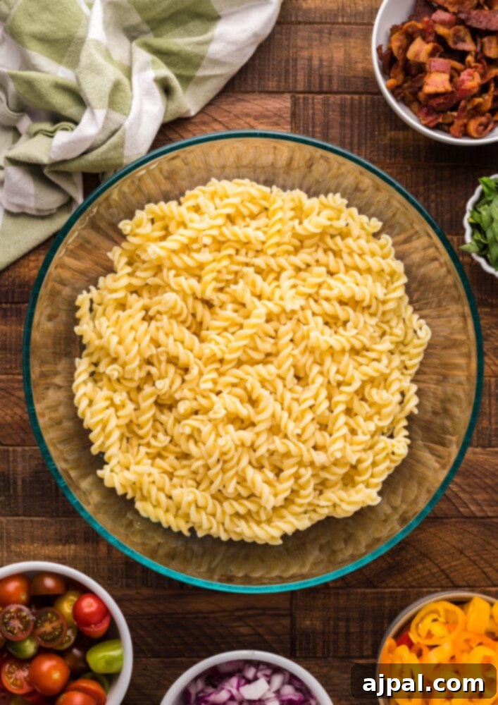 Velvet Chicken Bacon Pasta Salad 7 Cooked fusilli pasta noodles in a large bowl, perfectly al dente and cooled.