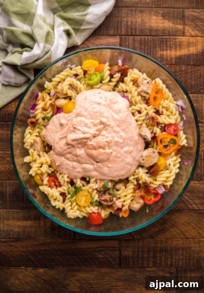 Velvet Chicken Bacon Pasta Salad 9 Prepared pasta, chicken, bacon, and vegetables tossed together in a large mixing bowl, before the dressing is added.