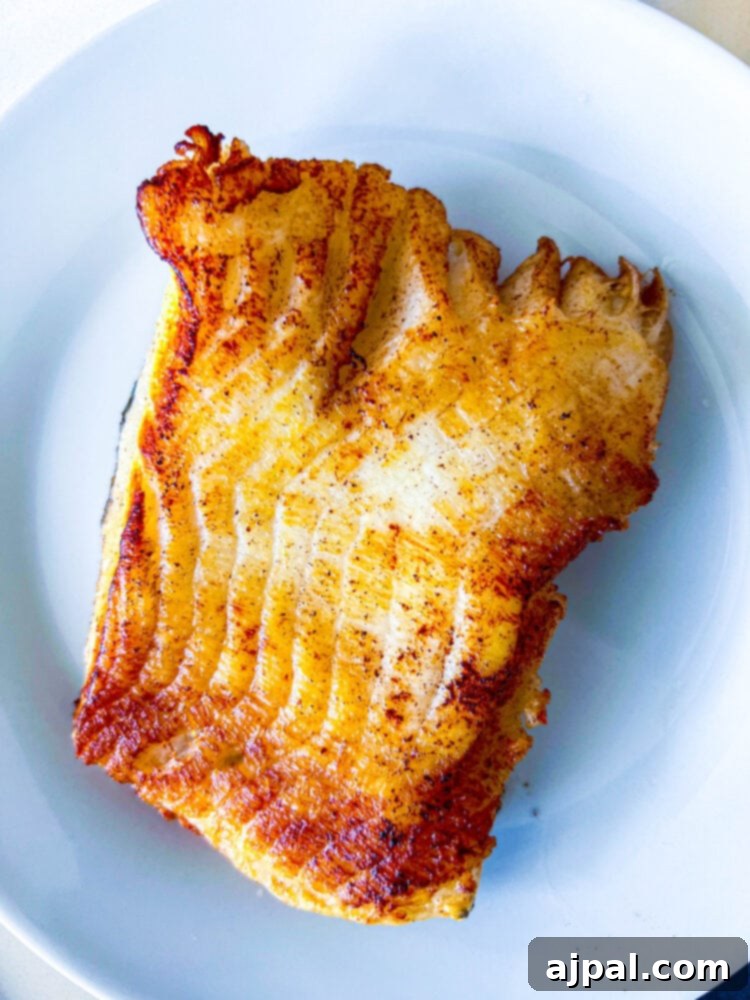 Pan-Seared Chilean Seabass with Lemon Caper Butter 7 A perfectly browned and seared Chilean seabass fillet resting on a plate after cooking.