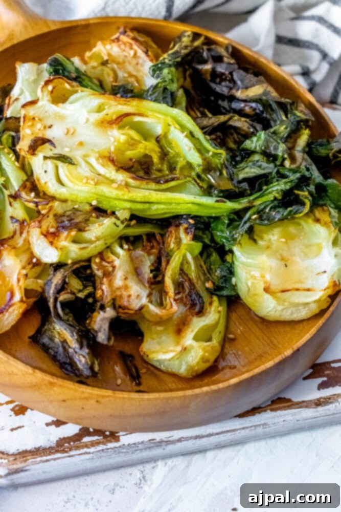 Grilled Sesame Ginger Bok Choy 2 Roasted bok choy on a wooden plate, highlighting its tender leaves and charred edges.