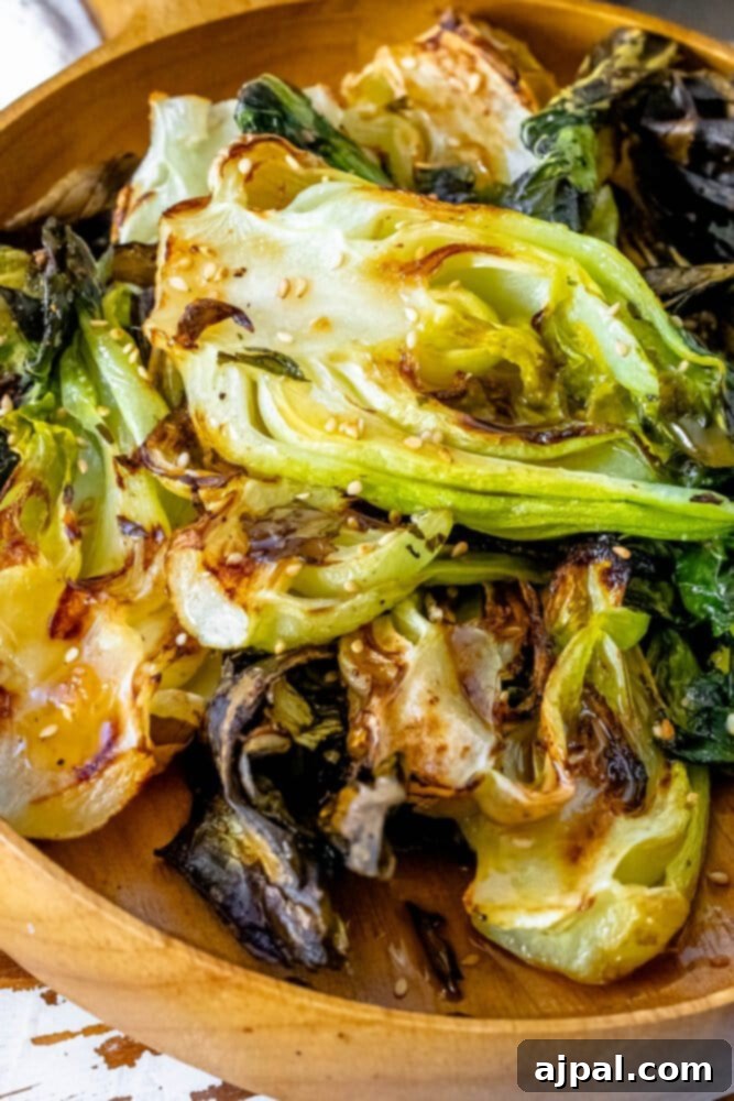 Grilled Sesame Ginger Bok Choy 4 A wooden bowl filled with beautifully grilled bok choy, showcasing its vibrant green and white stalks.