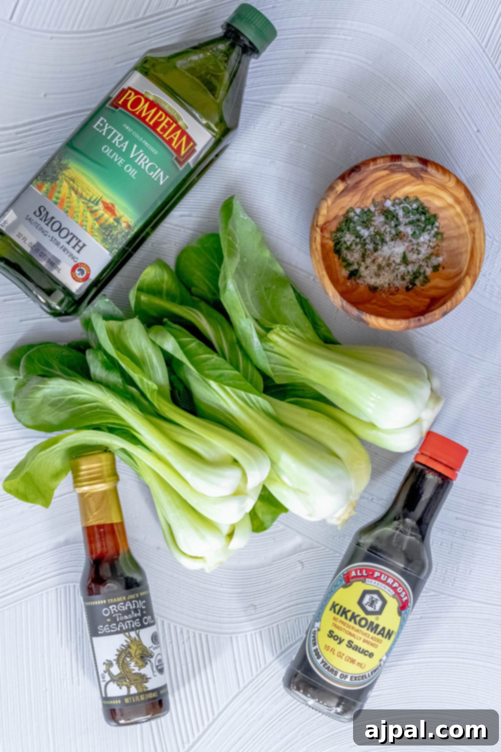 Grilled Sesame Ginger Bok Choy 5 A picture of the fresh ingredients for grilled bok choy: olive oil, bok choy, ginger, sesame oil, and soy sauce artfully arranged on a table.
