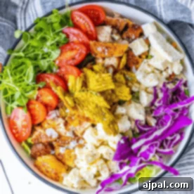 A bowl of jalapeno chicken salad with tomatoes, lettuce, and feta cheese.