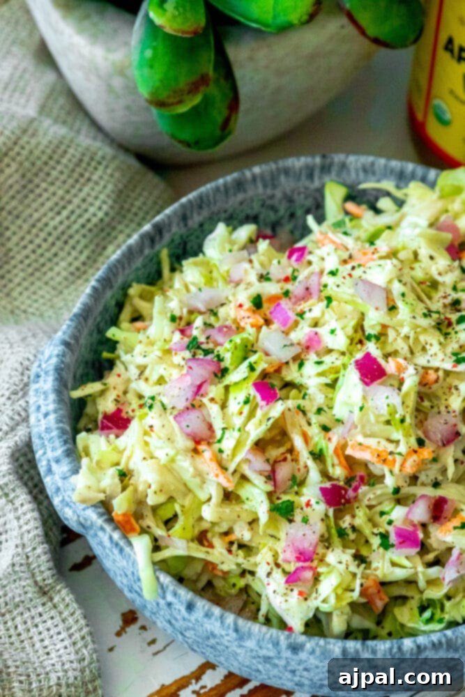 Quick & Easy 4-Ingredient Coleslaw 4 Homemade coleslaw in a serving bowl, ready to be enjoyed with a bottle of dressing nearby.