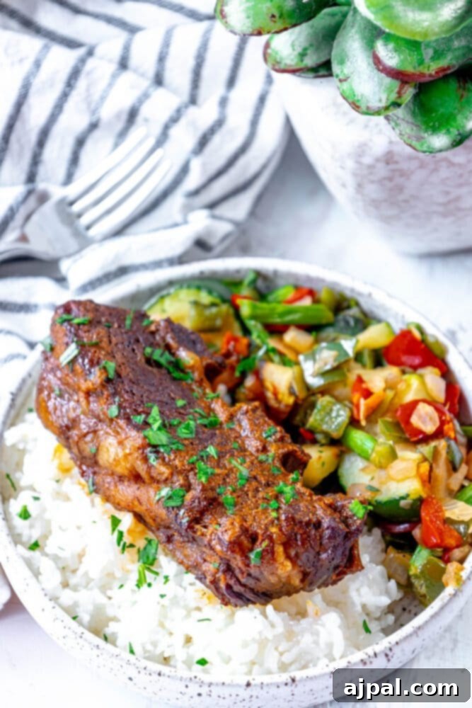 A bowl of rice and vegetables with a plant in the background, topped with spicy beef short ribs.