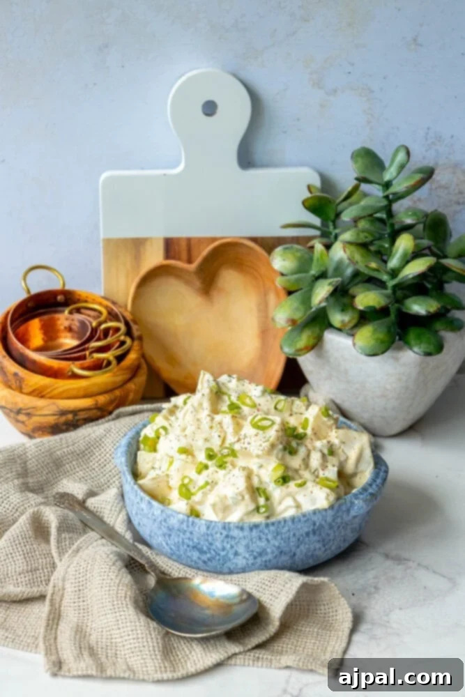 Simple & Scrumptious Potato Salad 4 A delicious and easy potato salad placed next to a cutting board, ready to be served.