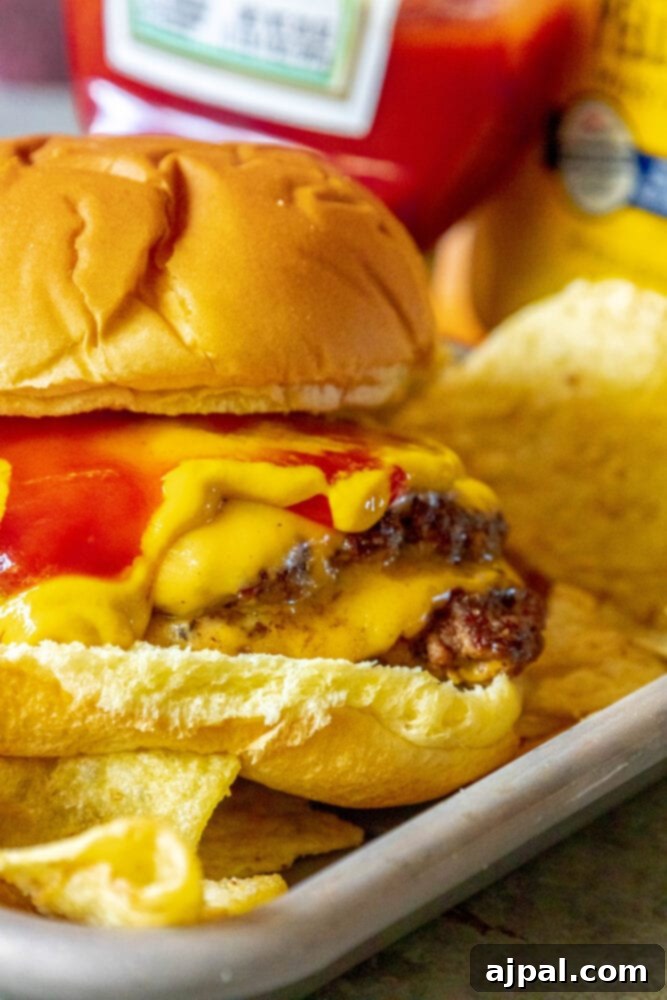 Griddled smashed cheeseburger in a bun on a metal plate