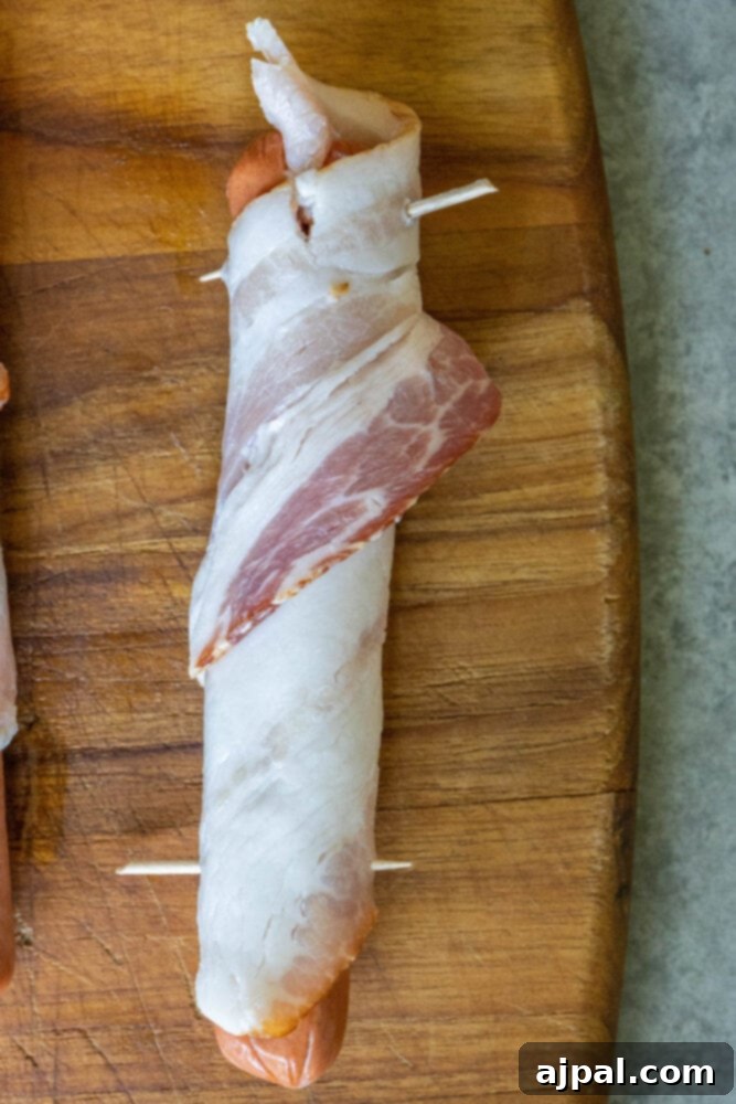 picture of bacon wrapped around a hot dog with toothpicks holding it in place