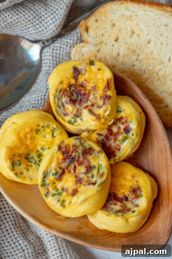 Fluffy Instant Pot Egg Bites 5 A rustic wooden plate holds five delectable egg bites, generously infused with bacon and cheese, with a soft loaf of bread blurred in the background, creating an inviting breakfast scene.